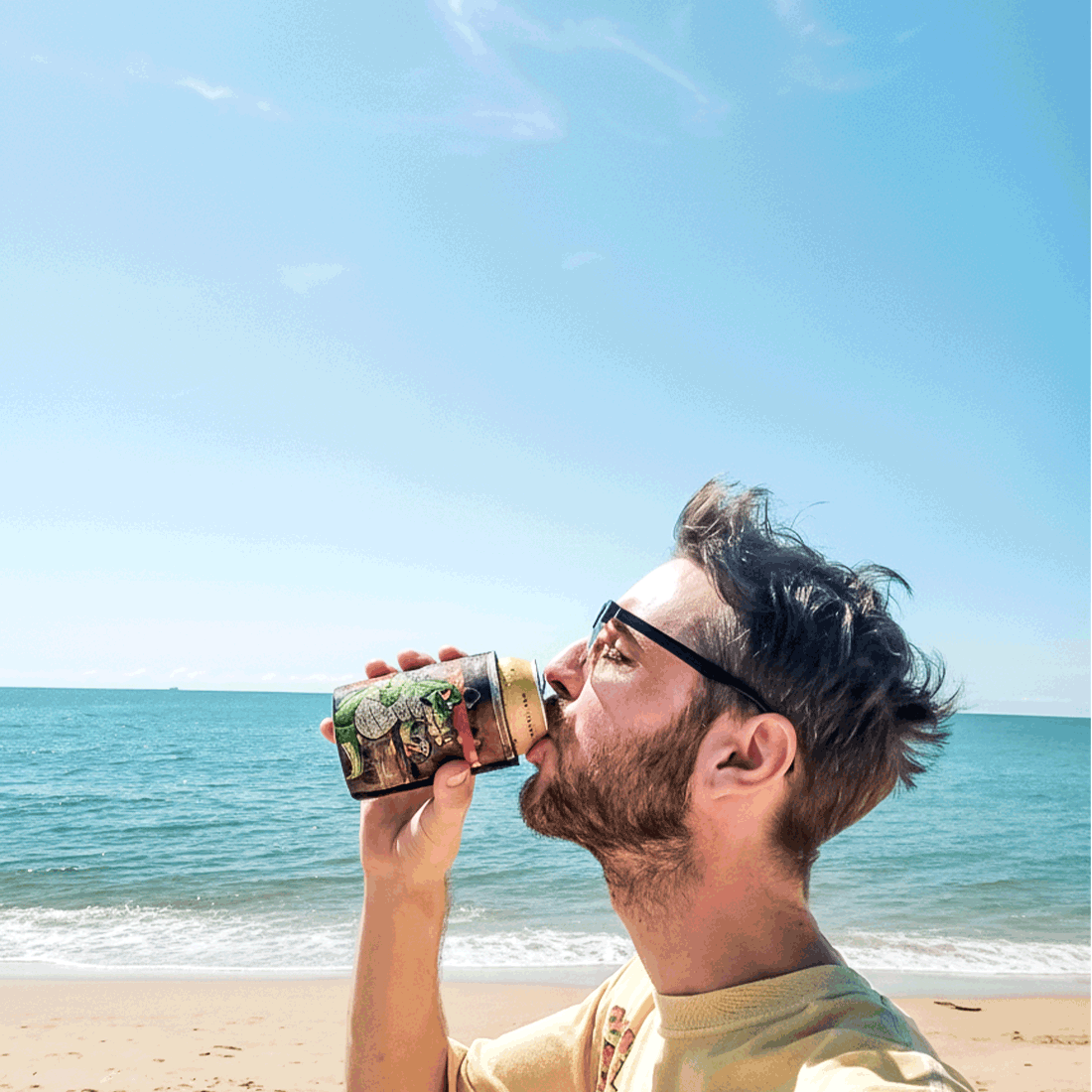 The owner of T-shirt Dealer Daniel drinking a beer on the beach in Cairns, Australia.